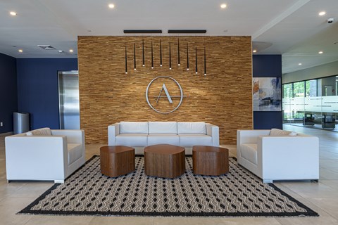 a living room with couches and tables in front of a brick wall